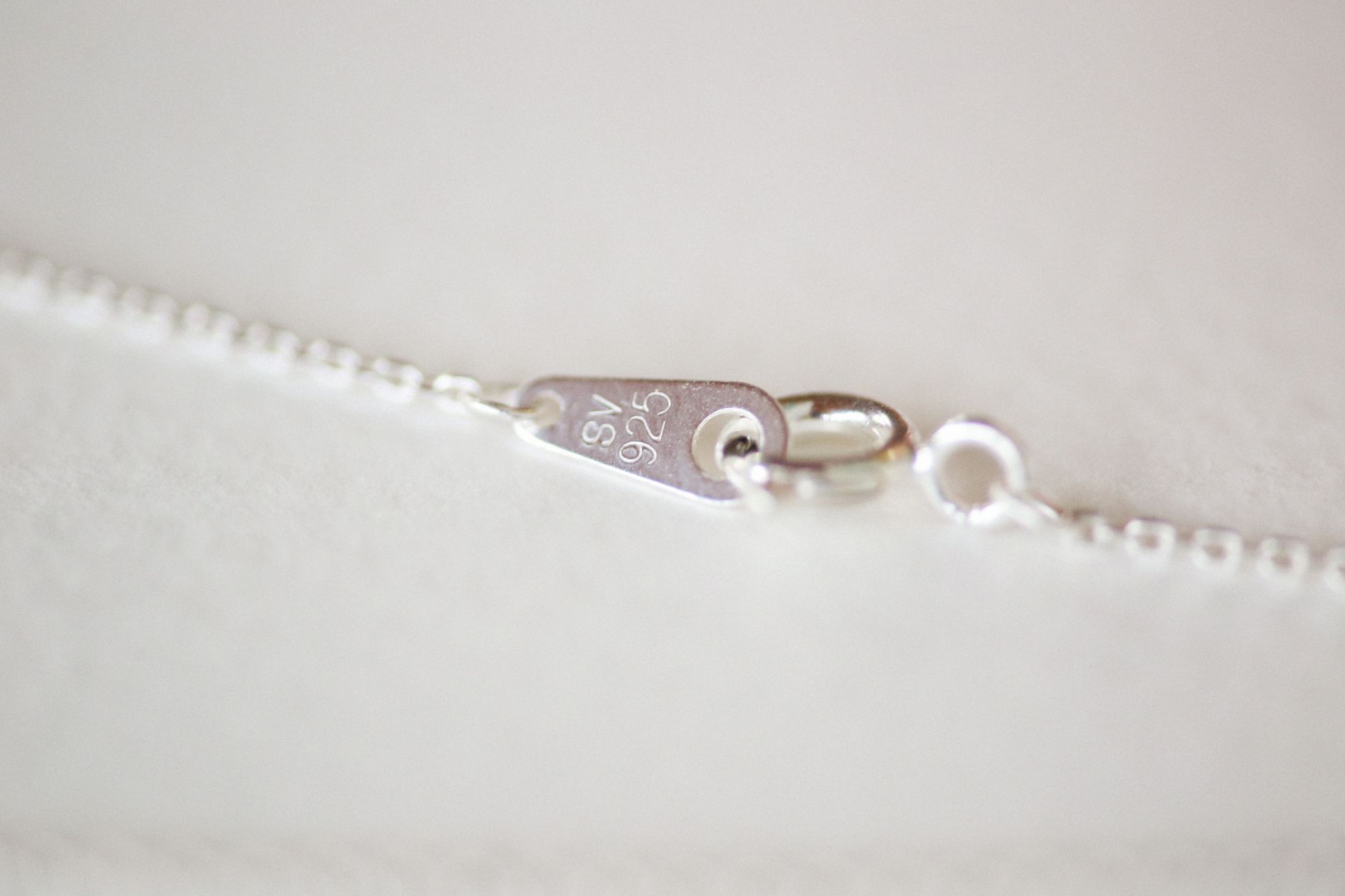 Chaine en argent posee sur un tissu sombre