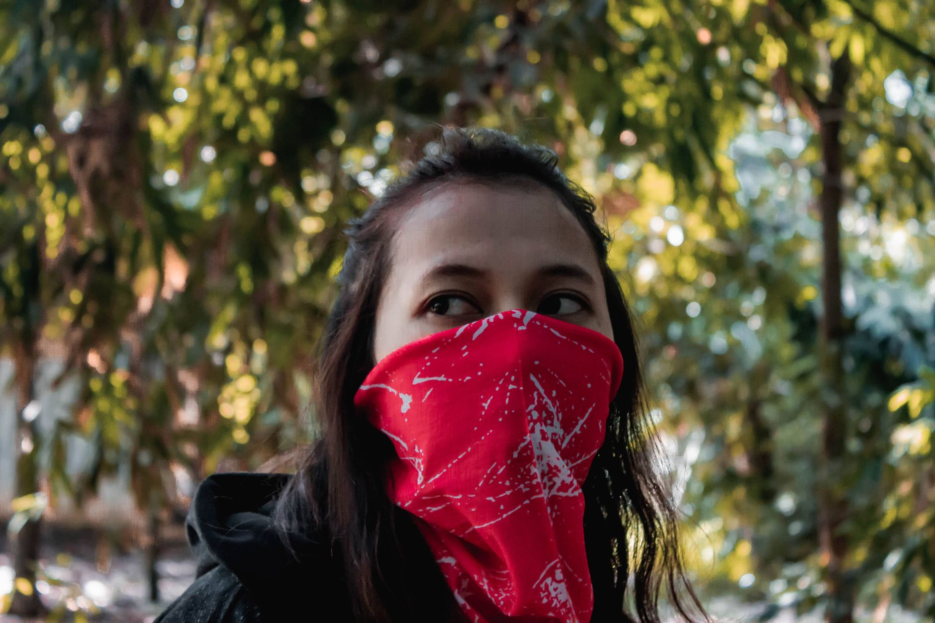 Bandana rouge remonté sur le bas du visage, porté en tour de cou