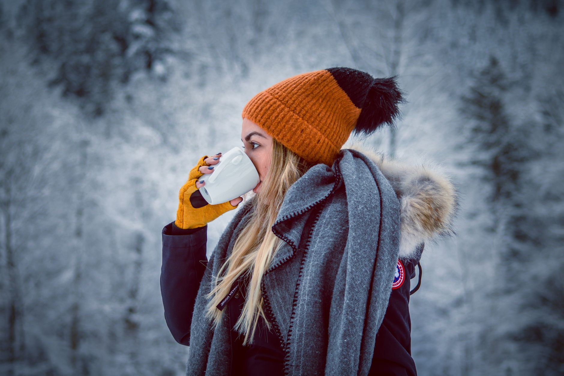 Femme emmitouflée dans son écharpe avec une boisson chaude