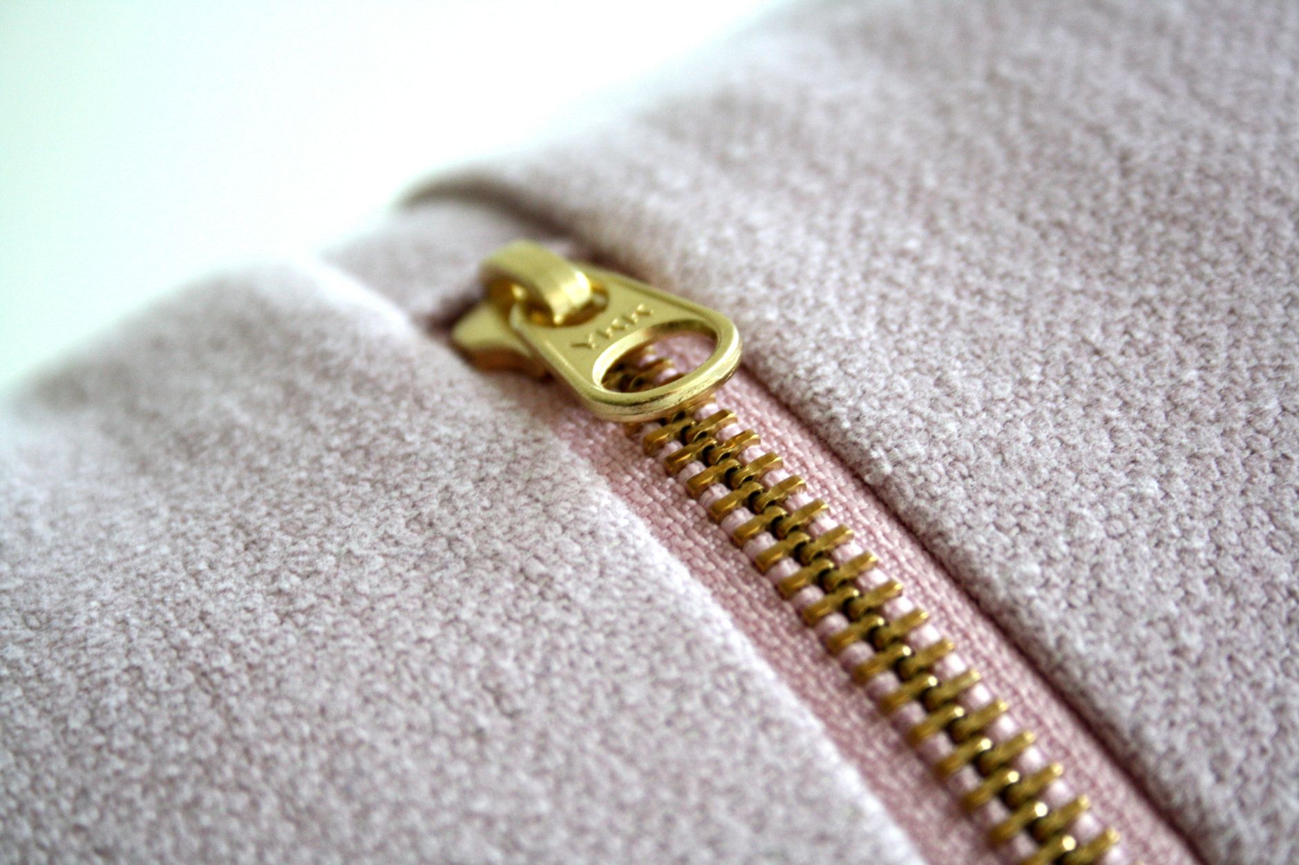 Fermeture éclair dorée sur un textile rose