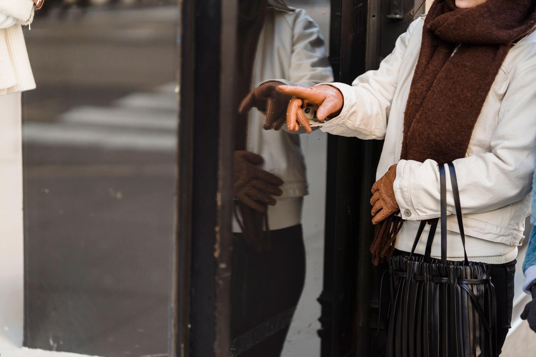 Femme gantée devant une vitrine de boutique