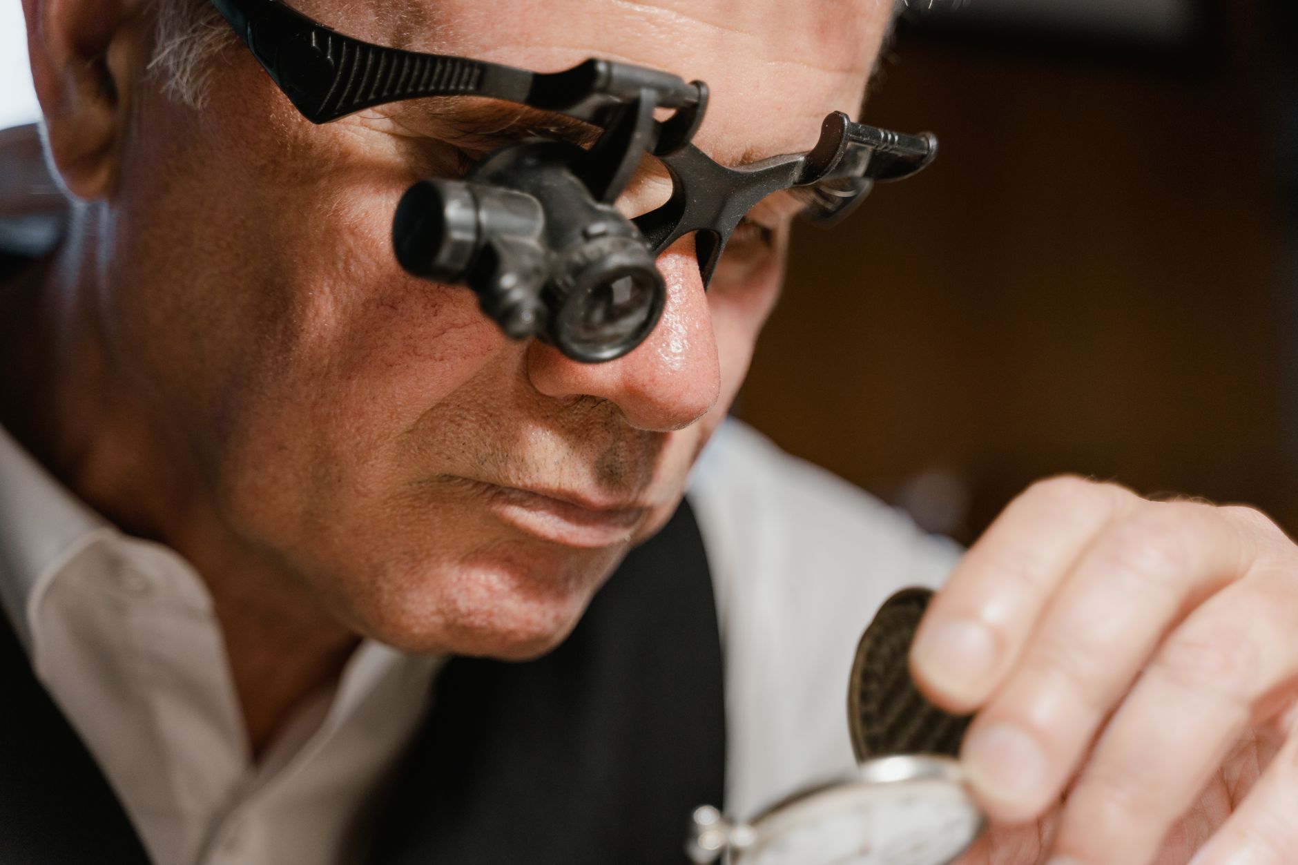 Horloger examinant une pièce à la loupe
