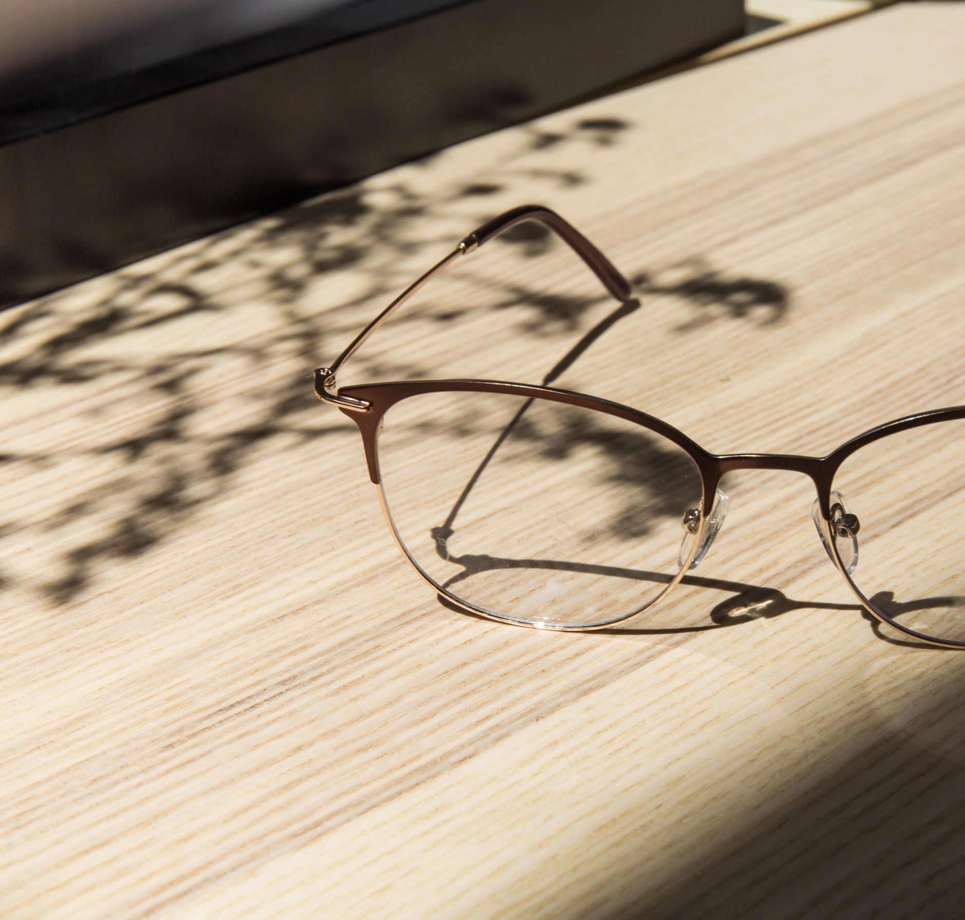 Lunettes posées sur une table en bois au soleil