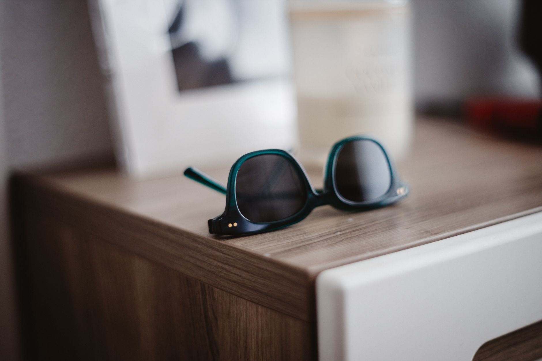 Monture sombre aux verres teintés sur une table en bois