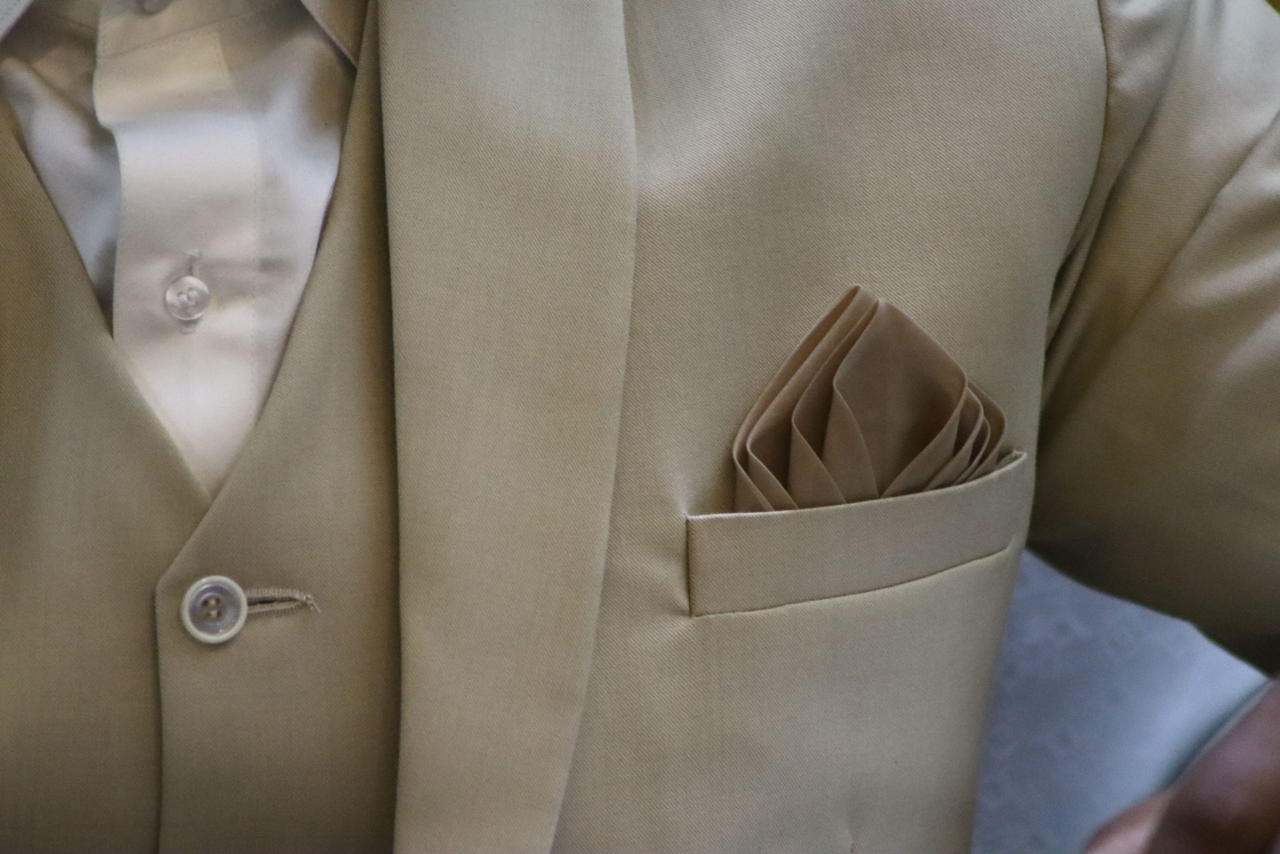 Veste beige avec pochette pliée dans la poche poitrine